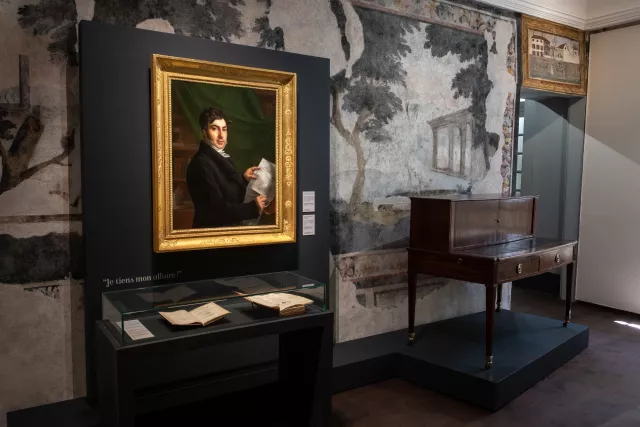 Photographie de la salle du déchiffrement au Musée Champollion, exposant le portrait de Jean-François par Mme de Rumilly et son bureau. © Département de l'Isère / Musée Champollion / Jean-Sébastien Faure
