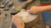 Atelier "Peuples de chasseurs, peuples de producteurs" au Musée de l'Ancien-Évêché. Un enfant découvre les techniques la Préhistoire par la manipulation. © Département de l'Isère