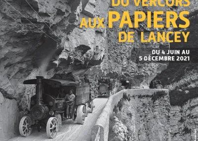 Camion à vapeur transportant un chargement de bois sur la route des Grands Goulets (Vercors), photo en noir et blanc. Affiche de l'exposition temporaire "Des forêts du Vercors aux papiers de Lancey" © Jean-Jacques Barelli
