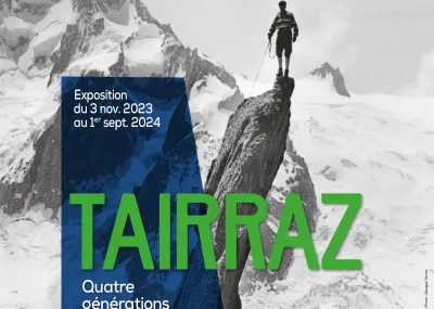 Affiche de l'exposition "Tairraz, quatre générations de photographes" composée d'une photographie en noir et blanc montrant un homme au sommet d'un pic rocheux devant un paysage de montagne