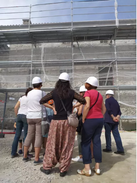 Visite du chantier du futur Musée Champollion Un groupe de visiteurs devant le chantier du futur Musée Champollion