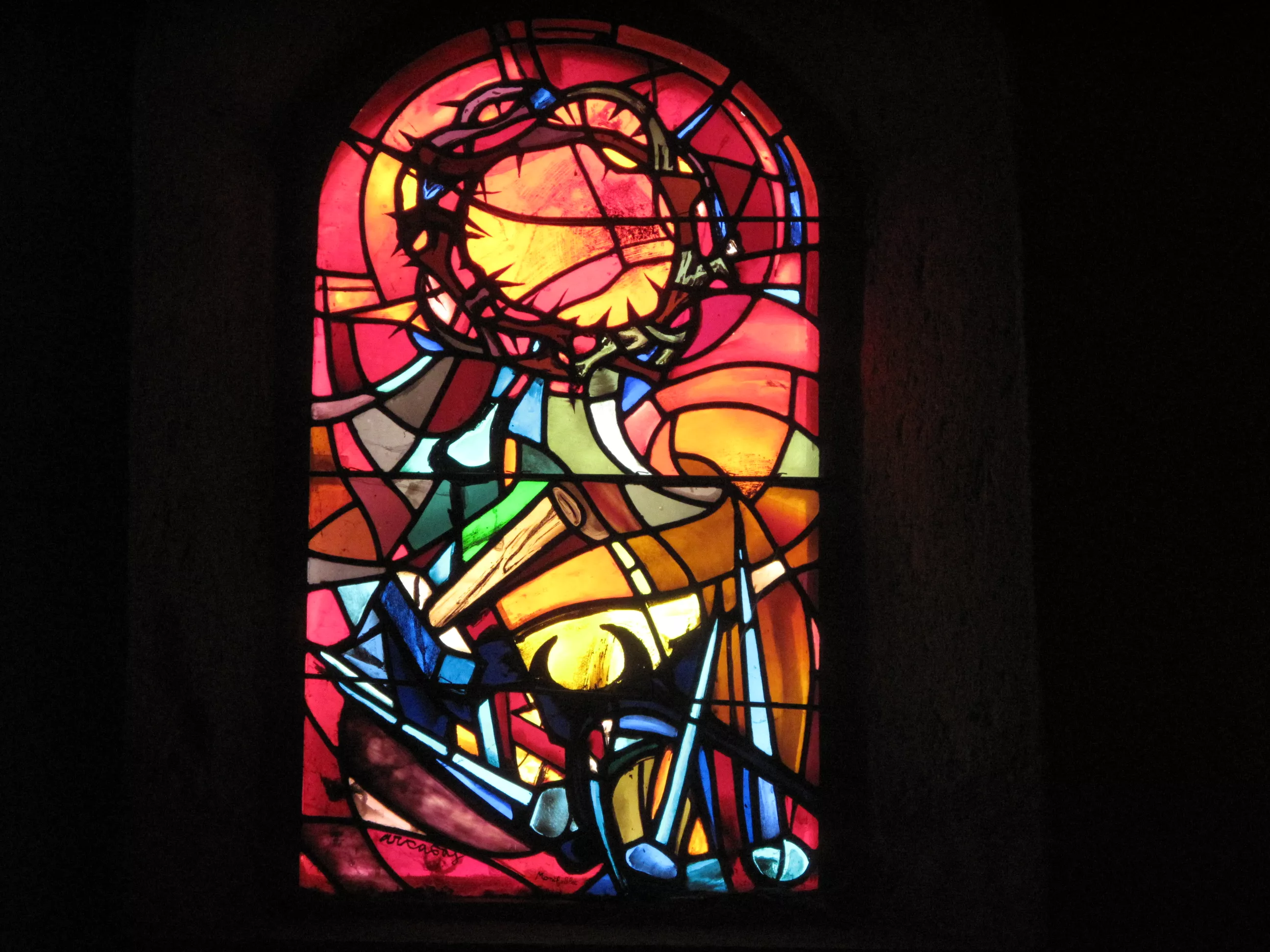 Une couronne d'épine, des tenailles, un marteau et des clous sur fond rouge et jaune.