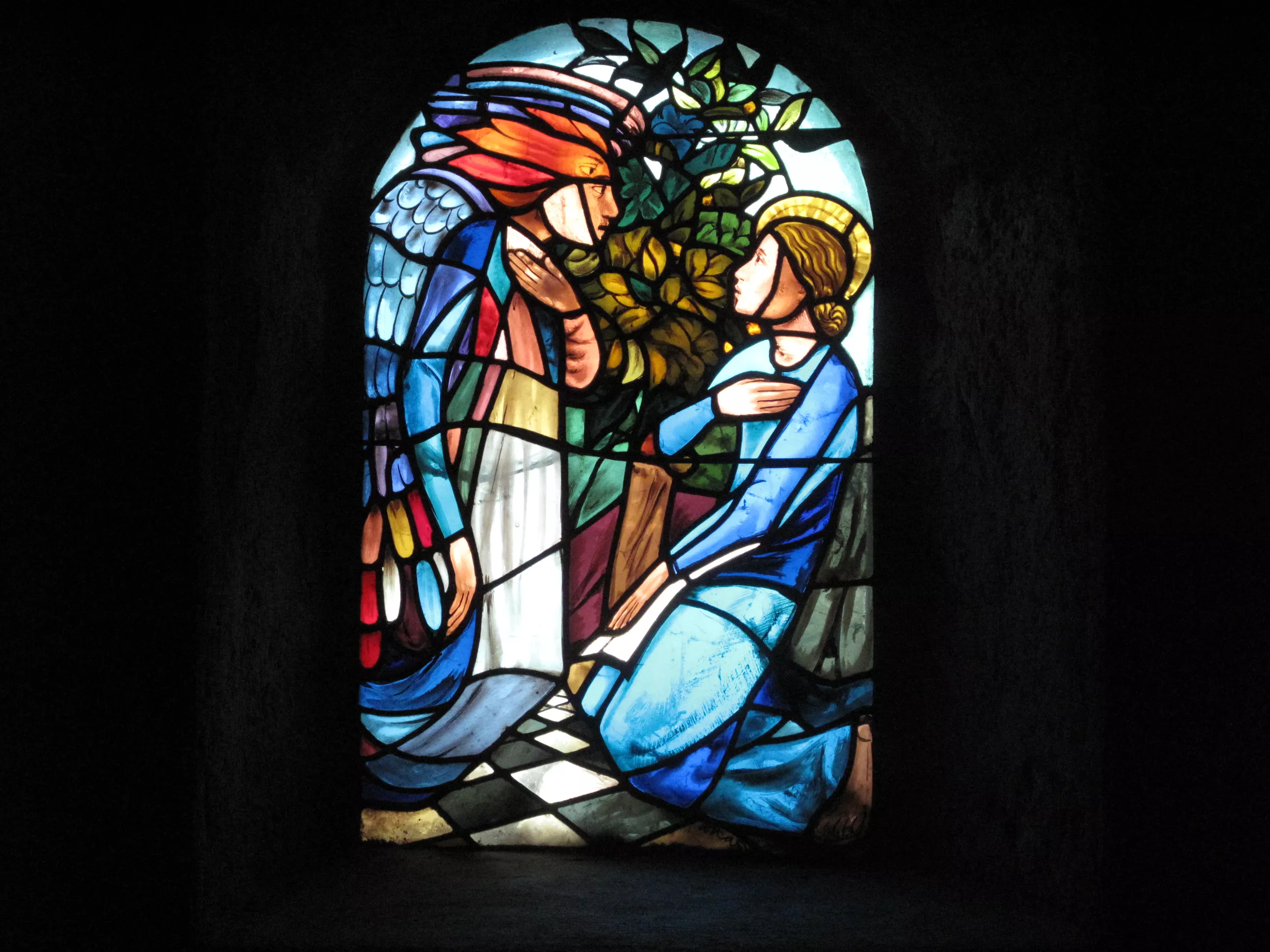 Un ange aux cheveux de feu, face à Marie, agenouillée, vêtue de bleu