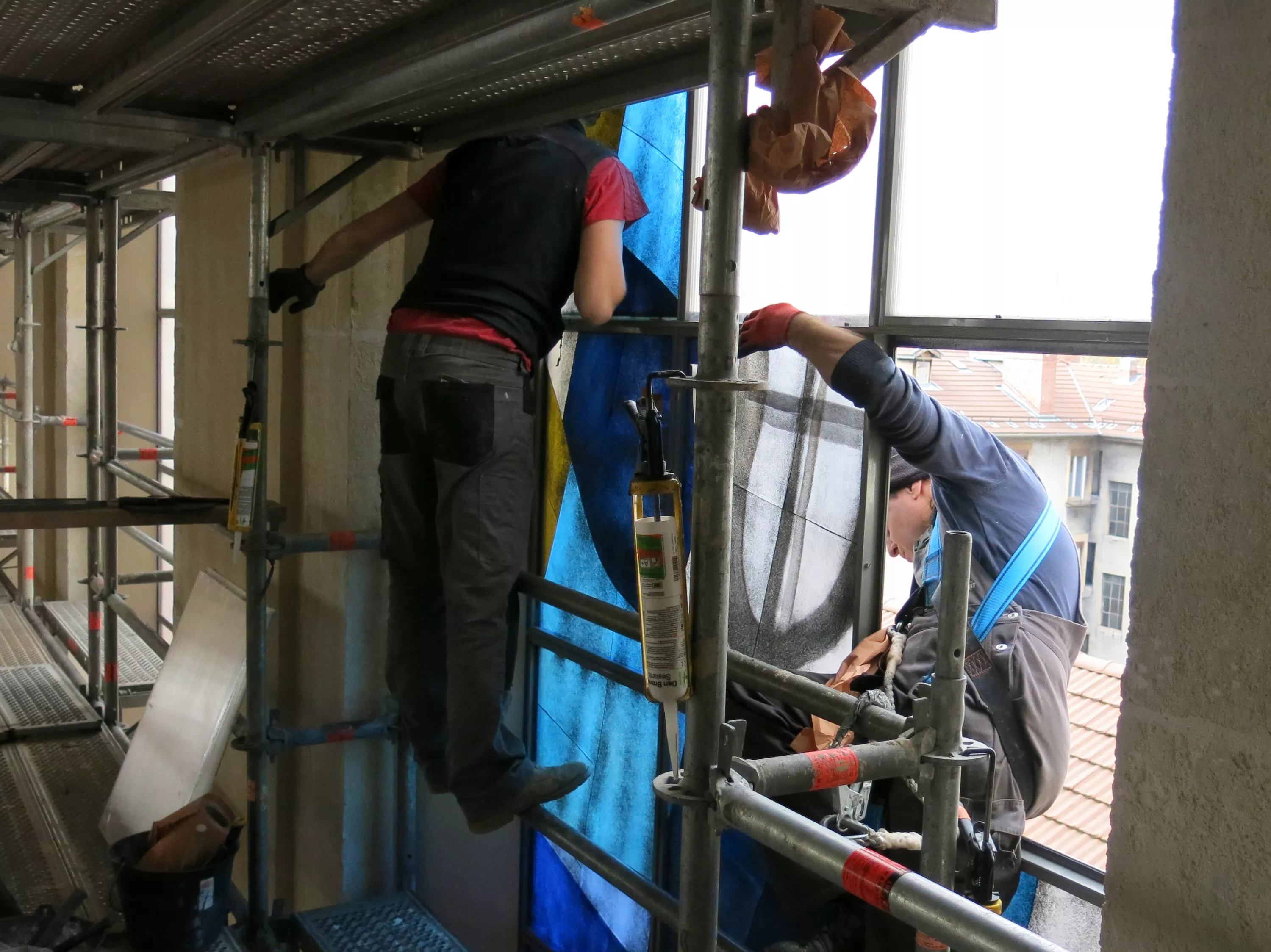 Pose d'un vitrail Deux hommes posent un vitrail