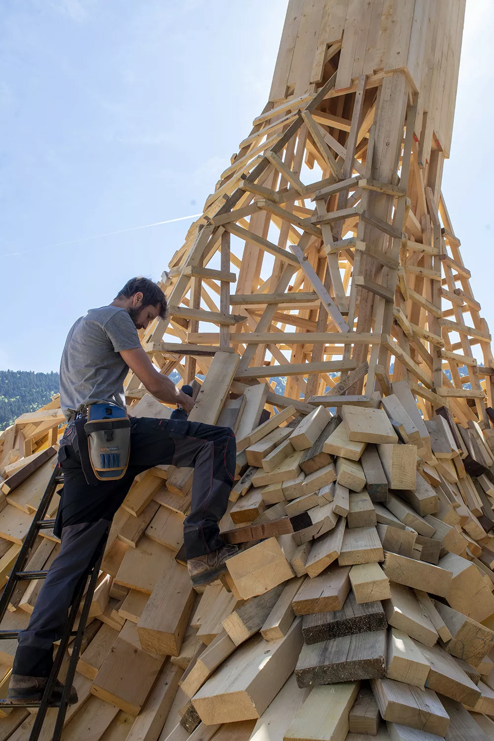L'artiste Simon Augade assemble les chutes de bois sur la structure de son oeuvre &quot;Fondement(s)&quot;