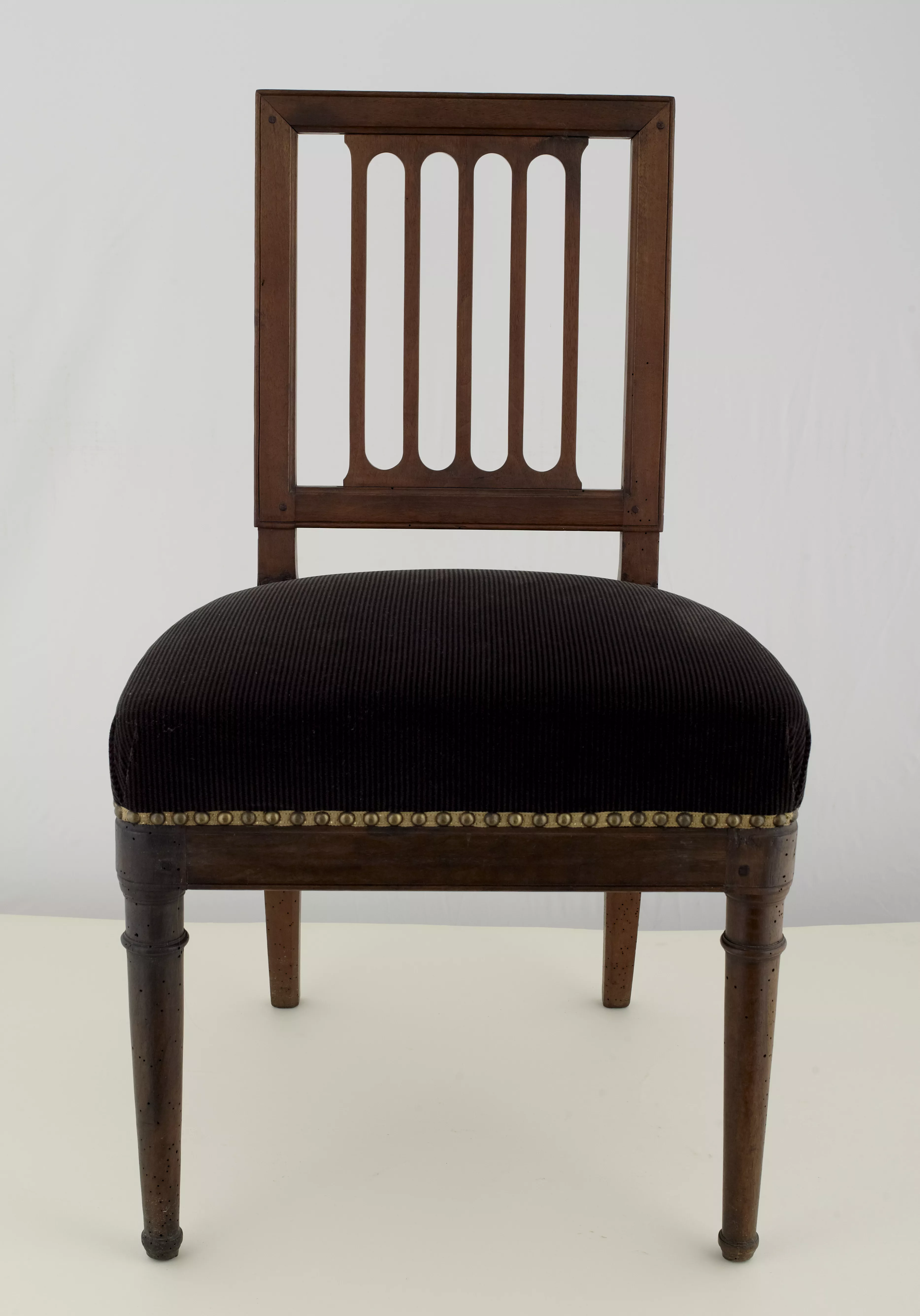 Photographie d'une chaise en acajou avec une assise tapissée de velours noir côtelé