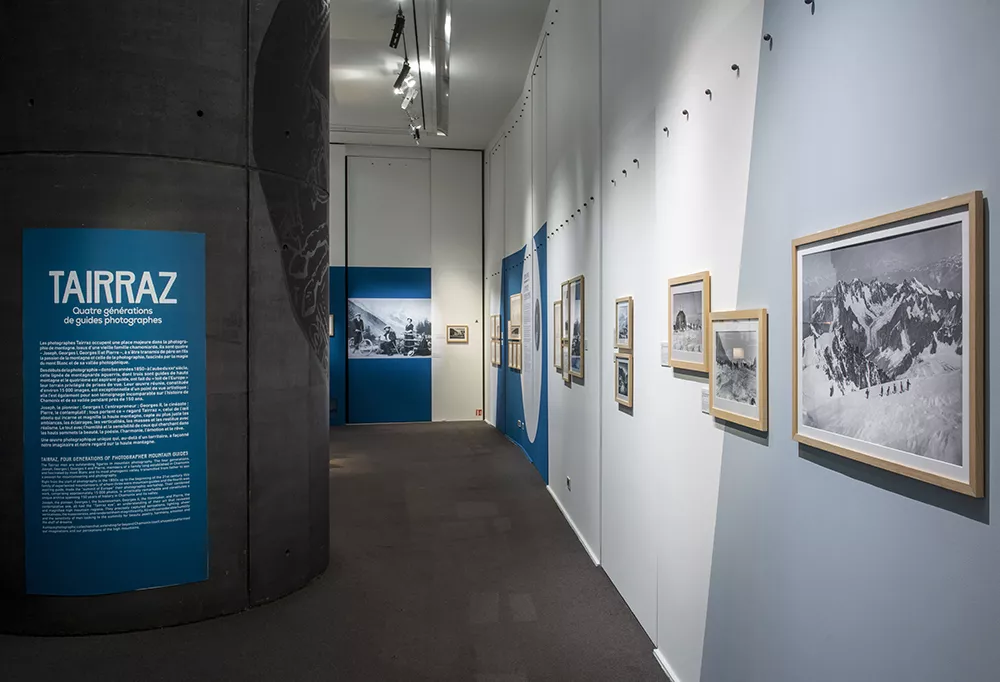 Photographie d'une salle de l'exposition &quot;Tairraz&quot; présentant des photographies de montagne en noir et blanc et des textes explicatifs