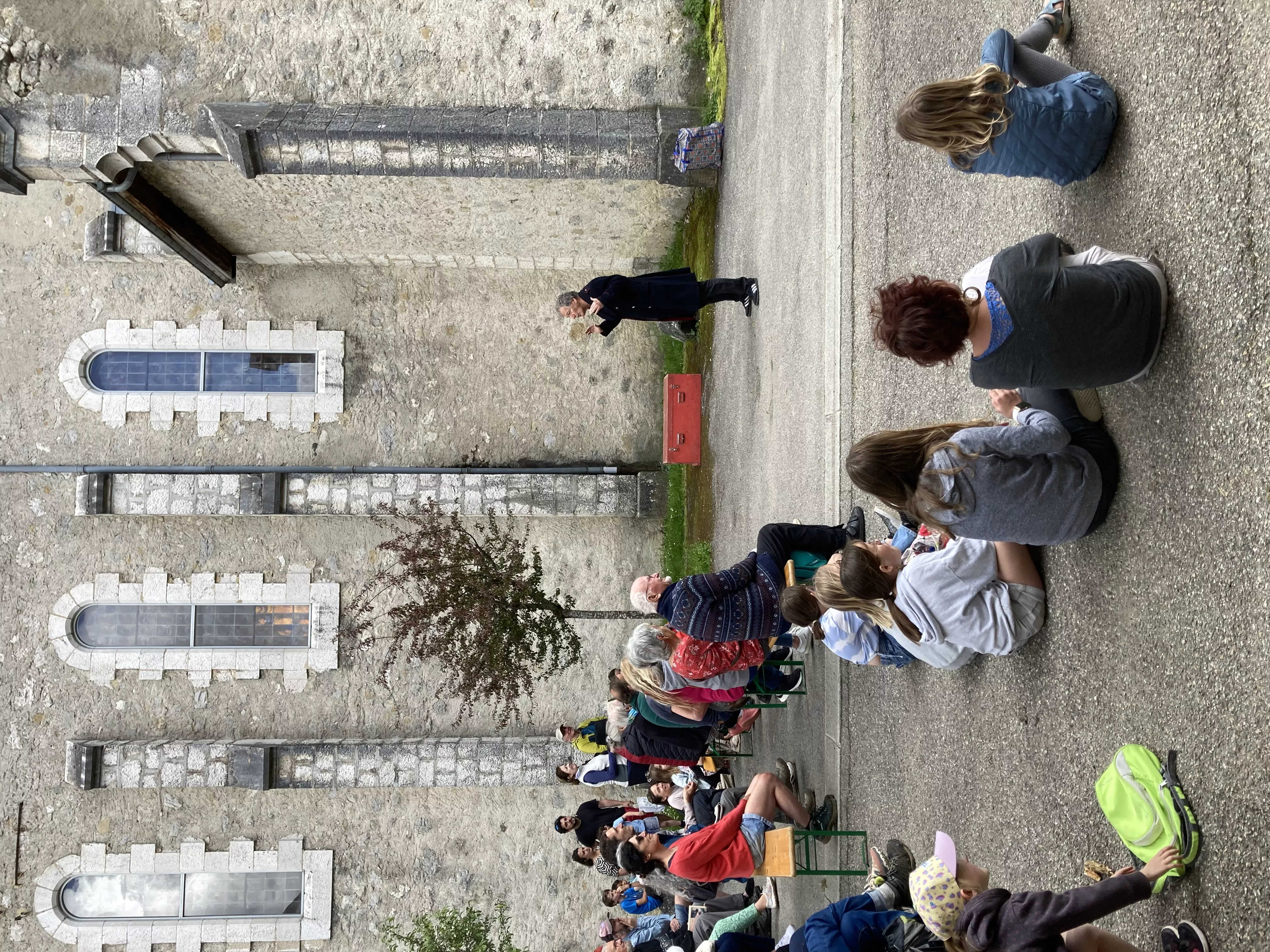 Photographie de l'inauguration de l'exposition &quot;Text'îles&quot; avec le Turak Théâtre devant l'église d'Arcabas en présence d'un public intergénérationnel