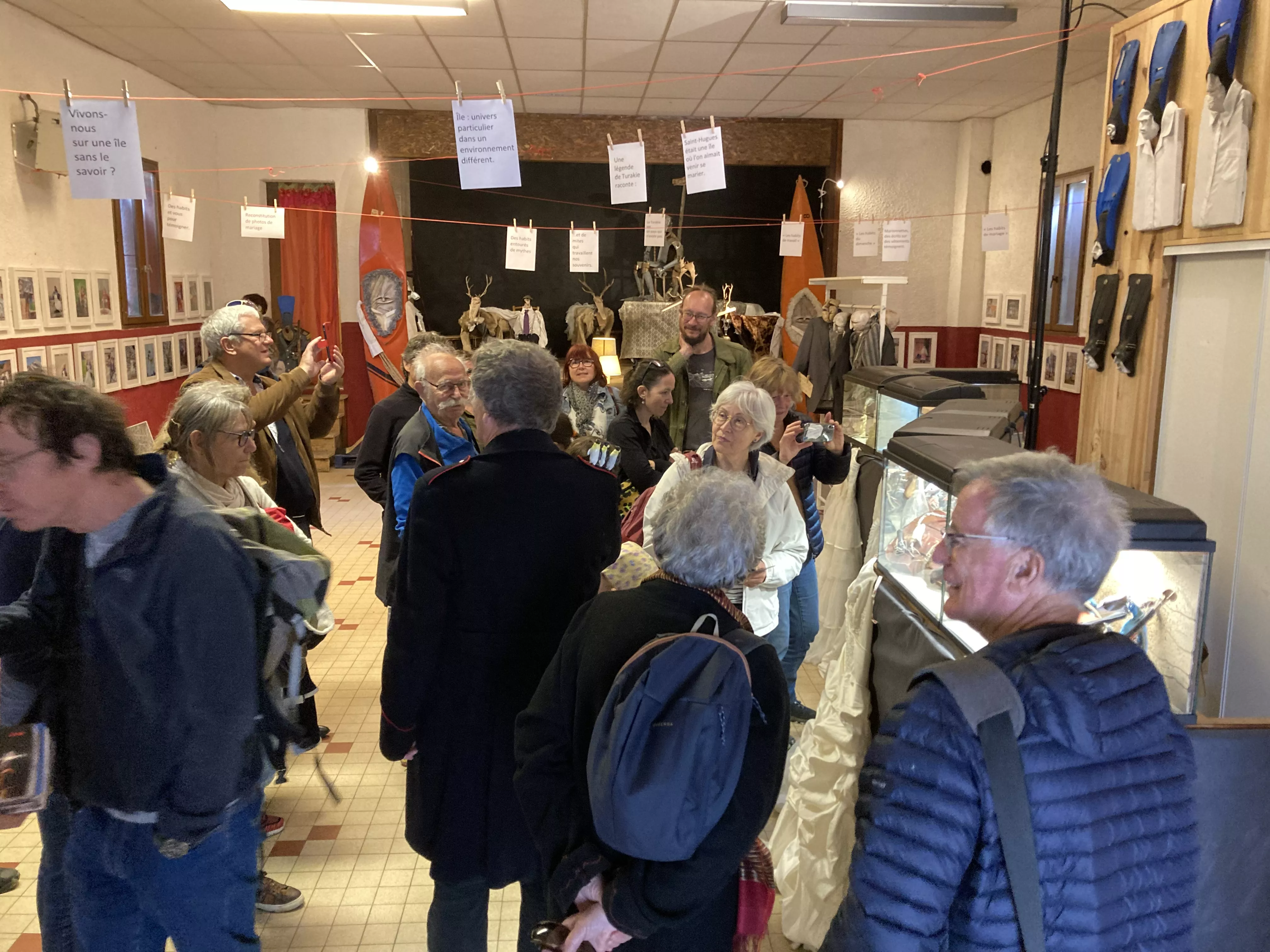 Photographie de l'inauguration de l'exposition &quot;Text'îles&quot; montrant des visiteurs regardant les objets insolites fabriqués par le Turak Théâtre