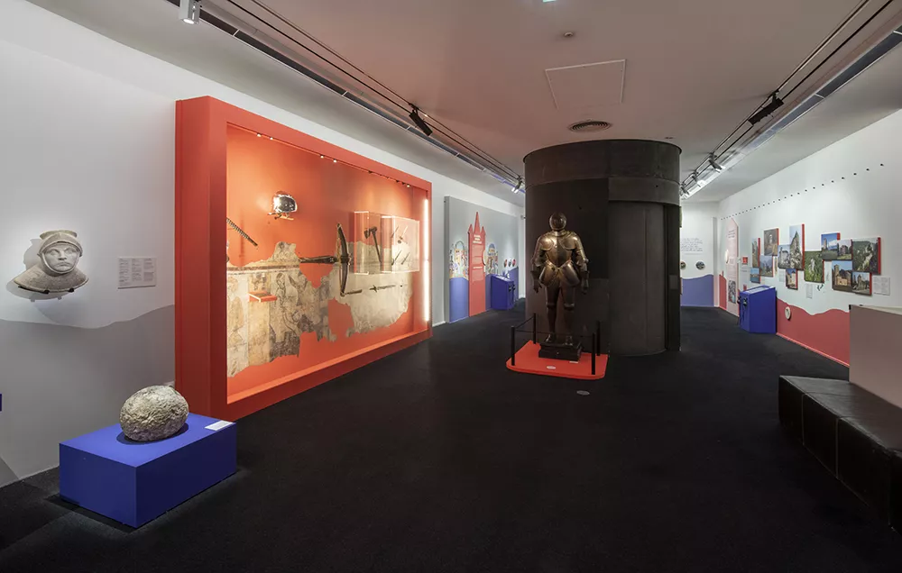 Vue large de la deuxième salle d'exposition avec au centre, une armure