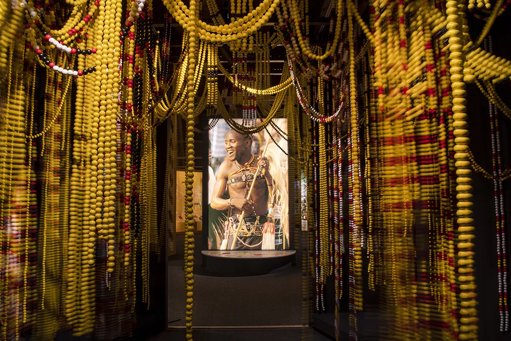 Entrée de l'exposition ornée de colliers de perles jaune et rouge