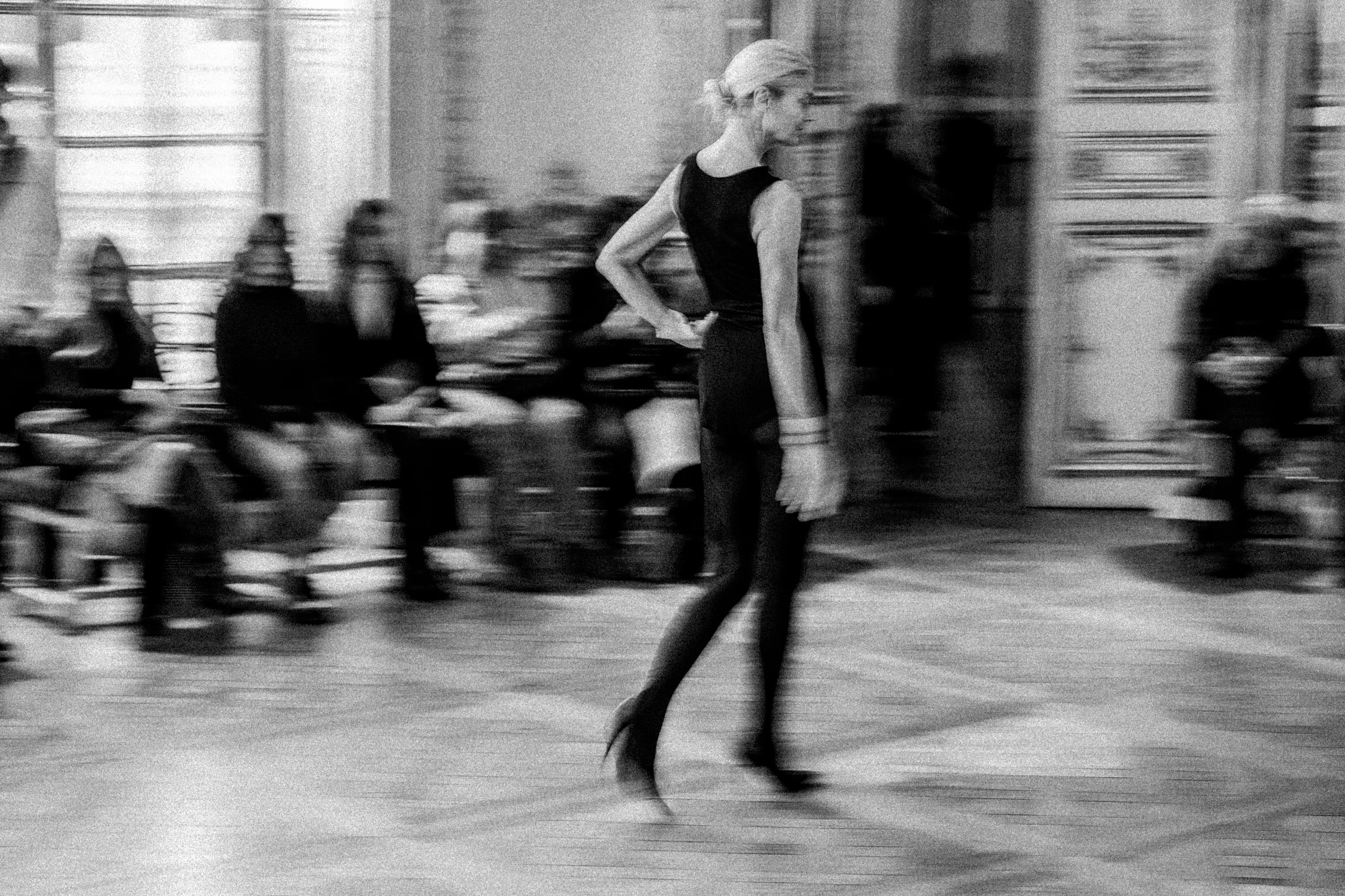 Photo en noir et blanc : mannequin qui défile lors d'une performance d'Olivier Saillard