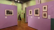 Photographie d'une salle de l'exposition "Comment m'habillerai-je" au musée de la Révolution française montrant des tableaux et une tenue d'époque dans une scénographie verte et violette