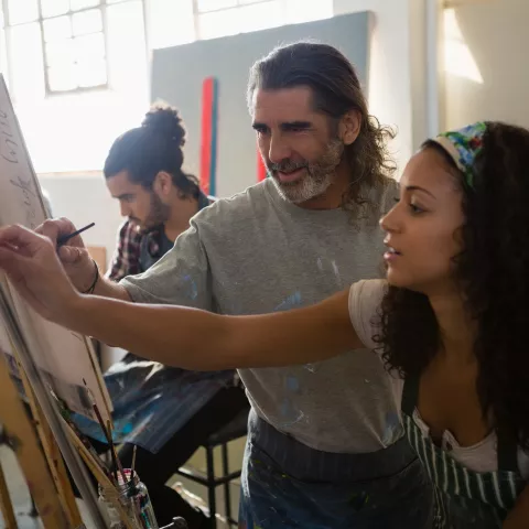 jeune femme et homme peignant sur un chevalet