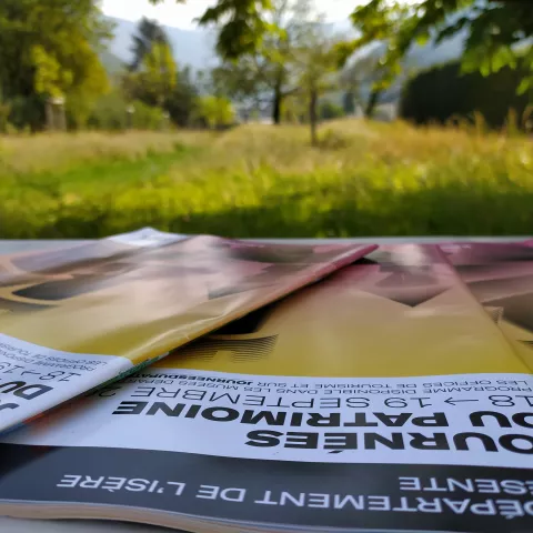 Flyers posés sur une table devant le Parc Champollion © Département de l'Isère / Musée Champollion