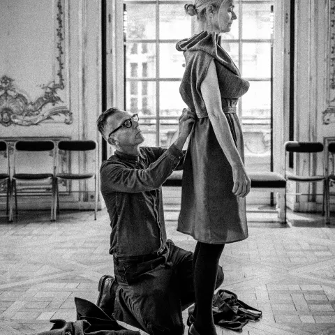 Photo en noir et blanc : Olivier Saillard habillant une mannequin lors d'une performance
