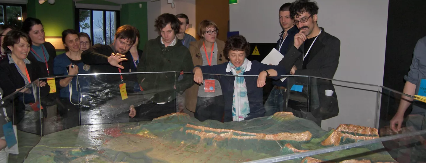 Groupe devant le plan-relief de la vallée du Grésivaudan, réalisé par Maurice Bergès, présenté dans la salle 1 Visiteurs devant le plan-relief de la vallée du Grésivaudan