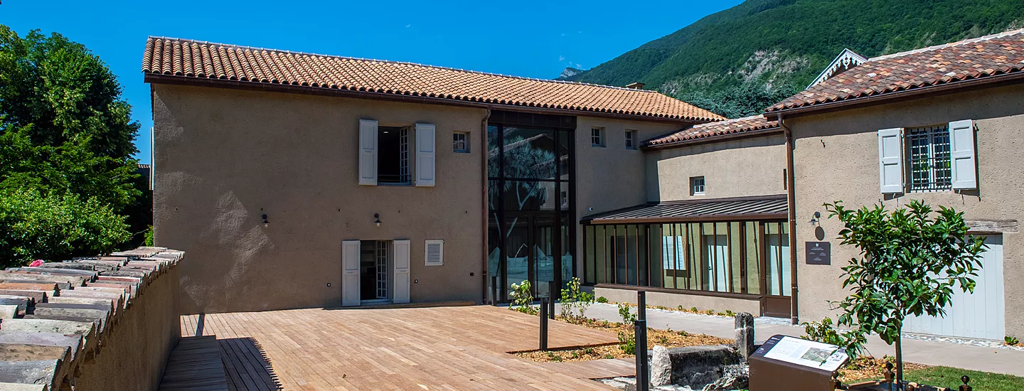 Photographie des bâtiments du musée Champollion avec sa terrasse au premier plan