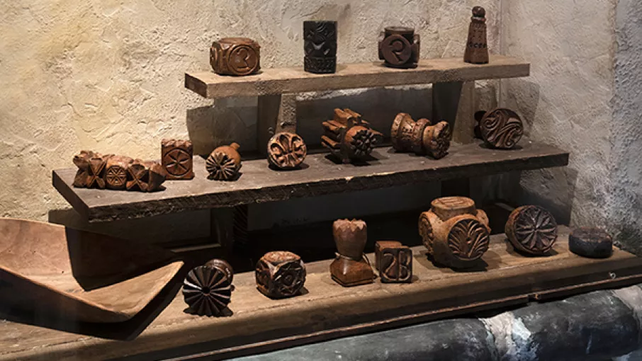 Photographie montrant des objets en bois gravés issus de l'exposition Alpins au musée dauphinois
